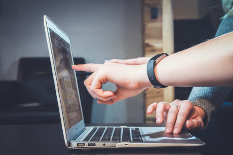 Image of people pointing to laptop screen